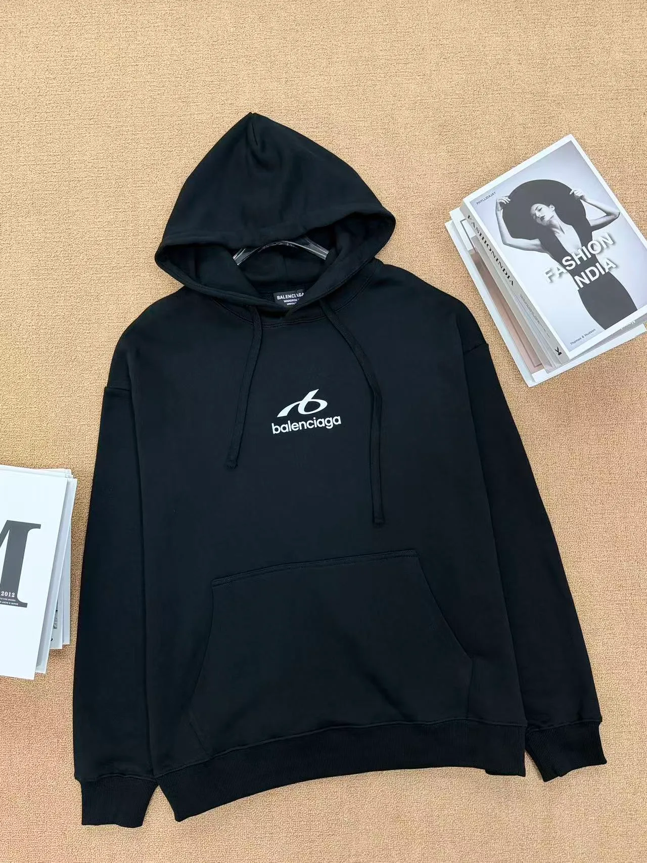 Style No. 2209 Style: Balenciaga small label embroidered hooded sweatshirt Color: Available in Black and Cream White Style: Loose shoulder wide version, same style for men and women, not picky on body shape, with a full, lazy and relaxed feel. Fabric technology: Selected 420g high-weight pure cotton terry fabric, thick and impermeable, soft and delicate to the touch. The logo is simply embroidered on the chest, and the stitching is dense and neat, making it difficult for the thread to come off. The hat has double-layer splicing, a large kangaroo pocket, the drawstring details are in place, and the cuffs and hem are tightly threaded to prevent them from loosening and deforming after long-term wear. Design highlights: Minimalist chest reflective design, no complicated printing, low-key and high-end. Basic black and white Classic color matching, Versatile is eye-catching and not easy to clash with in daily life. The loose cut makes the upper body look slimmer and is very tolerant to all body shapes. Wearing scenarios: Suitable for daily commuting, shopping, and traveling. The bottoms can be paired with jeans, sports pants, or skirts. They can be worn alone. They also look great when paired with a jacket in autumn and winter. A pair for couples will create a great atmosphere.